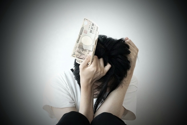 お金を手に頭を抱える。美作市で弁護士や司法書士に債務整理の無料相談をする